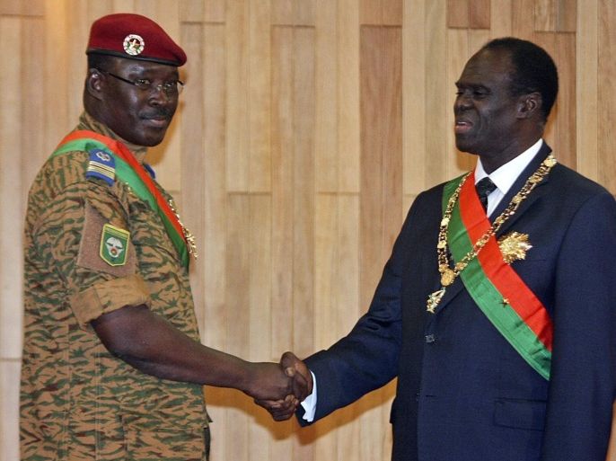 (FILE) A file picture dated 18 November 2014 shows Michel Kafando (R) shaking hands with Lieutenant-Colonel Isaac Zida (L) after being sworn in as the country's transitional president in Ouagadougou, Burkina Faso, 18 November 2014. According to media reports on 17 September 2015, Burkina Faso guards loyal to ousted President Blaise Compaore detained interim President Michel Kafando and Prime Minister Isaac Zida after bursting into a cabinet meeting on 16 September. In the capital Ouagadougou, the army troops fired shots to disperse hundreds of protesters gathering outside Burkina Faso's presidential palace where the detainees are being kept, media said. No injured or casualties have been reported. EPA/HERVE TAOKO BEST QUALITY AVAILABLE
