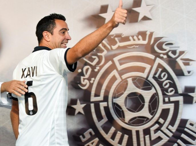 Former FC Barcelona player Xavi Hernandez wears his new Al-Sadd club jersey during a press conference in Doha, Qatar, 11 June 2015. The 35-year-old Xavi has signed a two-year contract.