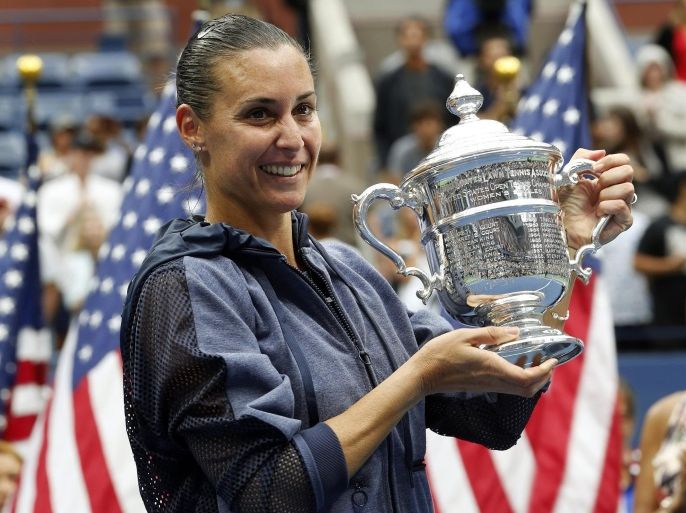 Flavia Pennetta, of Italy, holds up the championship trophy after beating Roberta Vinci, of Italy, in the women's championship match of the U.S. Open tennis tournament, Saturday, Sept. 12, 2015, in New York. (AP Photo/Julio Cortez)