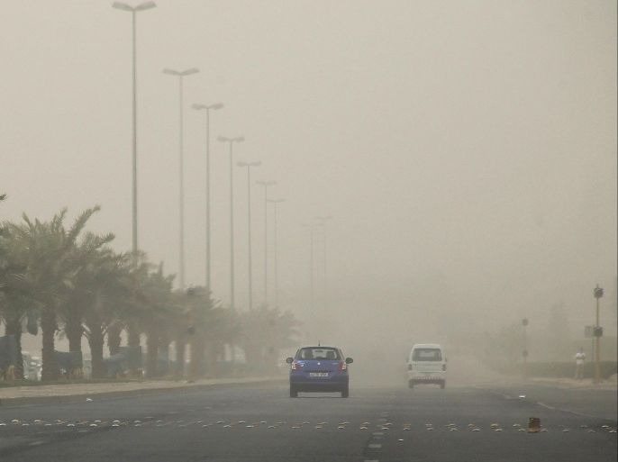 Cars drive along the street in Kuwait City during a heavy dust storm on July 7, 2015. AFP PHOTO / YASSER AL-ZAYYAT