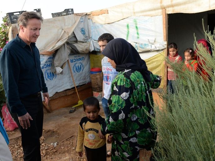 Britain's Prime Minister David Cameron (L) meets Syrian refugee families at a tented settlement camp in the Bekaa Valley on the Lebanese-Syrian border on September 14, 2015. Cameron arrived in Beirut on September 14 for a one-day visit to discuss the Syrian refugee crisis gripping the Middle East and Europe, a Lebanese government source said. Cameron was to visit a refugee camp in the Bekaa valley in eastern Lebanon, the source said. The country hosts more than 1.1 million Syrian refugees. is in the region to see conditons and meet those who have fled their homes in Syria. AFP PHOTO / POOL / STEFAN ROUSSEAU
