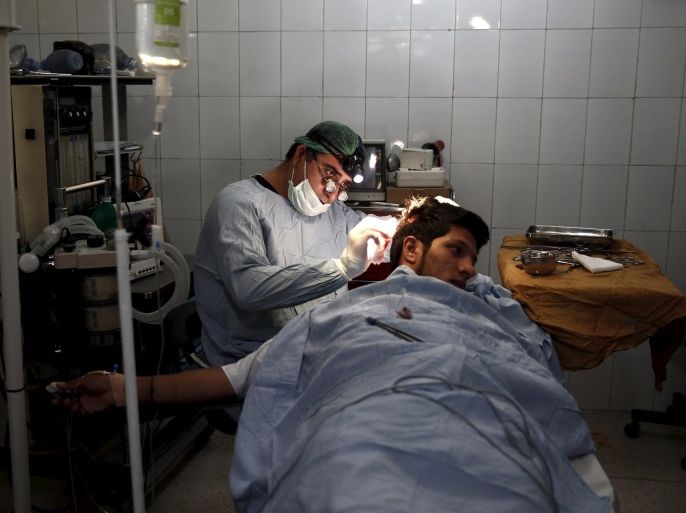 Plastic surgeon Abdul Ghafar Ghayur performs surgery on a patient at Aria City Hospital, in Kabul, Afghanistan August 6, 2015. Ghayur is practising his own brand of welfare in Afghanistan, where access to healthcare is limited and many cannot afford private treatment. The money he makes from the hundreds of nose jobs and Botox injections he performs on wealthy Afghans allows him to perform life-changing surgery on low-income patients at a discount or sometimes for free. Ghayur's practice in the capital Kabul offers a microcosm of Afghan medicine, where doctors, driven by a sense of civic duty, try to fill huge gaps in a public health system devastated by decades of war. Picture taken August 6, 2015. REUTERS/Ahmad Masood