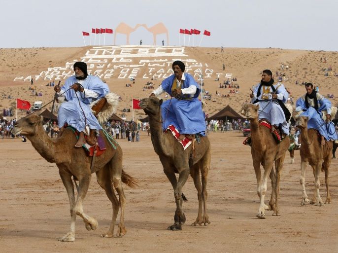 In this Saturday, Sept. 7 , 2013 picture, riders on camels perform before the start of the traditional Fantasia at the Moussem festival in Tan Tan, southern Morocco. The UNESCO-sponsored festival is a gathering of thousands nomads from Morocco. The Festival did not take place for 30 years before 2004 due to political conflict in Western Sahara. (AP Photo/Abdeljalil Bounhar)
