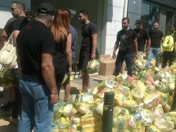 أعضاء من حزب الفجر الذهبي يوزعون مساعدات غذائية لليونانيين حصرا