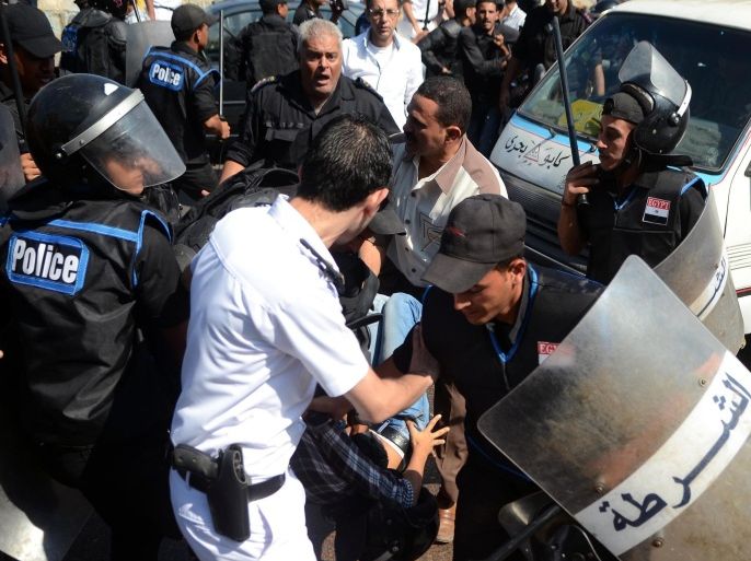 ALEXANDRIA, EGYPT - OCTOBER 1: Egyptian police officers detain a supporter of 28-year-old Khaled Said who died following police questioning in 2010, during clashes with police outside a court on October 01, 2013 in Alexandria, Egypt. The clashes erupted during the trial of two Egyptian police officers accused of beating Said to death in Alexandria in 2010. Egypts Alexandria Criminal Court has adjourned on Tuesday the retrial of the two policemen accused of torturing 28-year-old Khaled Said to death in Alexandria in 2010. The court will resume the trial on 2 December 2013.