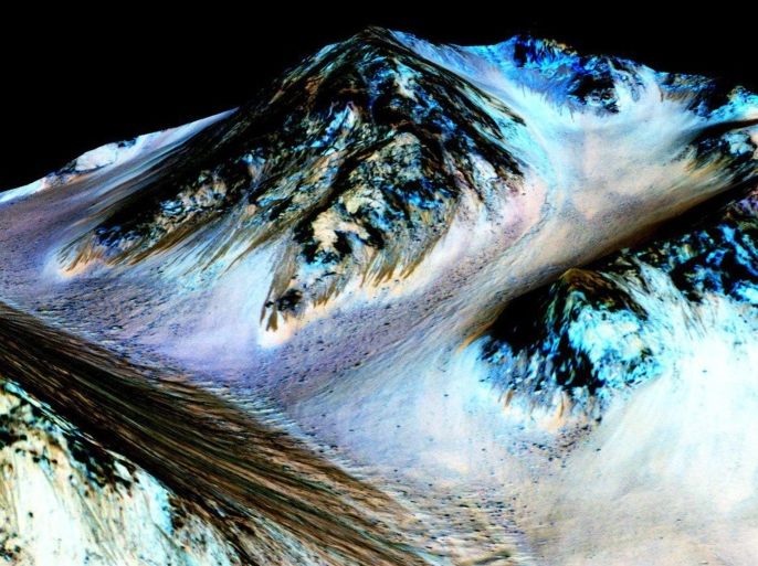 A handout image released by NASA on 28 September 2015 showing dark, narrow, 100 meter-long streaks called recurring slope lineae flowing downhill on Mars, inferred to have been formed by contemporary flowing water. Recently, planetary scientists detected hydrated salts on these slopes at Hale crater, corroborating their original hypothesis that the streaks are indeed formed by liquid water. The blue color seen upslope of the dark streaks are thought not to be related to their formation, but instead are from the presence of the mineral pyroxene. The image is produced by draping an orthorectified (Infrared-Red-Blue/Green(IRB) false color image (ESP_030570_1440) on a Digital Terrain Model (DTM) of the same site produced by High Resolution Imaging Science Experiment (University of Arizona). Vertical exaggeration is 1.5. EPA/NASA HANDOUT