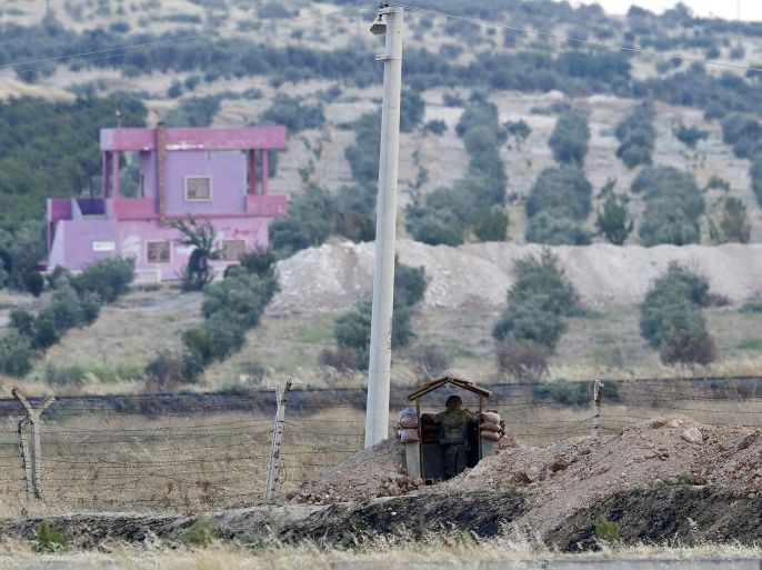 A Turkish soldier stands guard at the Turkish-Syrian border in Karkamis, bordering with the Islamic State-held Syrian town of Jarablus, in Gaziantep province, Turkey, August 1, 2015. Karkamis is a Turkish town of 10,500 people that sits directly opposite the border post. Shut for more than a year, the military sealed the crossing with a breeze block wall a few months ago. Behind it, just inside Syria, the black flag of Islamic State flaps in the breeze. Karkamis lies on the northeastern edge of a rectangle of Syrian territory some 80 km (50 miles) long, controlled by the radical Islamists. The United States and Turkey hope that by sweeping Islamic State from this border zone, they can deprive it of a smuggling route which has seen its ranks swollen with foreign fighters and its coffers boosted by illicit trade. Picture taken August 1, 2015. REUTERS/Murad Sezer