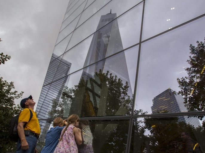 People peer through windows at the National September 11 Memorial and Museum in Lower Manhattan in New York, September 10, 2015. People from around the world visited the site on Thursday, the day before the 14th anniversary of the September 11 terrorist attacks. The 9/11 memorial and museum are located at the original site of the World Trade Center's North and South towers, which were destroyed in the attacks. REUTERS/Andrew Kelly