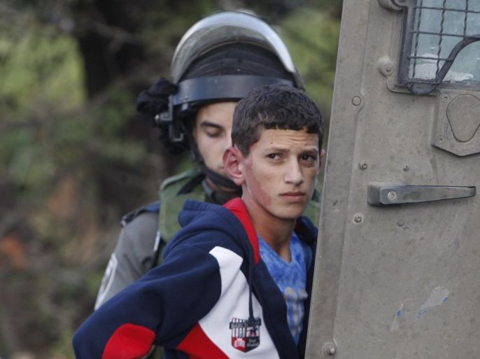 An Israeli border policeman detains a Palestinian youth near the scene of a stabbing attack, near the West Bank city of Hebron October 8, 2015. Four people, including an Israeli soldier, were stabbed and wounded near a military headquarters in Tel Aviv on Thursday, police and ambulance sources said, as a rash of such Palestinian attacks spread to Israel's commercial capital. REUTERS/Mussa Qawasma