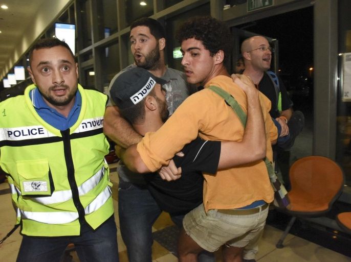 Israelis carrying a wounded Policeman injured during an attack allegedly carried out by Palestinian man, at the Bus station in Beersheba, Israeli, 18 October 2015. A man opened fire in a southern Israel bus terminal, killing one before authorities shot him dead, shattering a 24-hour lull in Palestinian attacks that has had the nation on the brink after a fortnight of violence. Security forces engaged in a gunbattle with the assailant, who had entered the station armed with a gun, but then also snatched the rifle of a soldier, police said. He was shot dead after fleeing outside. EPA/Dudu Grunshpan ISRAEL OUT
