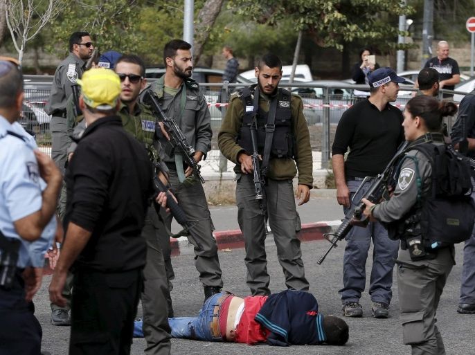 A Palestinian suspected of committing a stabbing attack is surrounded by Israeli border police at the scene of the attack in Jerusalem October 30, 2015. REUTERS/Ammar Awad