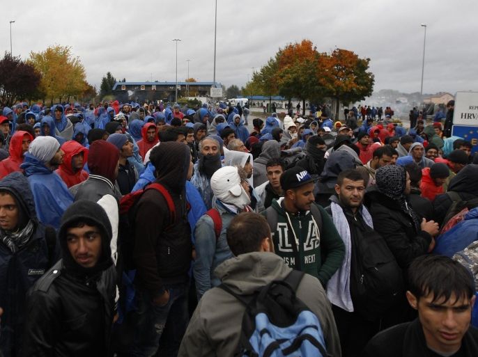 Migrants wait for a bus at the border between Croatia and Slovenia in Trnovec, Croatia, Monday, Oct. 19, 2015. Hundreds of migrants have spent the night in rain and cold at Croatia's border after being refused entry into Slovenia. (AP Photo/Petr David Josek)