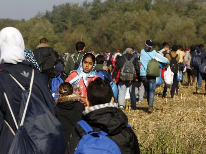 New refugees walk from Croatia to Slovenia through fields escorted by members of the Slovenian army near Rigonce village on the Slovenian border with Croatia, 24 October 2015. Many of the migrants are exhausted, they have been waiting for hours at the closed border in Croatia in the hope of entering Slovenia, the next stage on their long journey to Austria, Germany or Sweden. Europe is grappling with the biggest migrant influx since World War II, and more than half of those arriving are estimated to be from Syria.