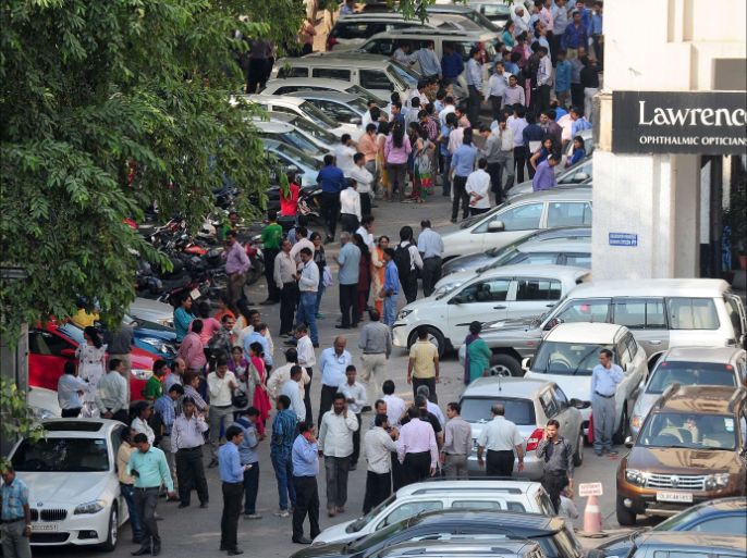 Indian office workers stand in an open area in a carpark following an earthquake in New Delhi on October 26, 2015. A strong earthquake lasting almost a minute was felt in New Delhi on October 26, with buildings shaking in the centre of the Indian capital