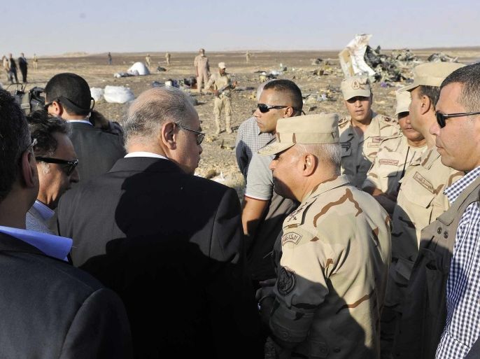 In this image released by the Prime Minister's office, Sherif Ismail, left, along with military and government officials, visit the site where a passenger plane crashed in Hassana Egypt, Friday, Oct. 31, 2015. A Russian aircraft carrying 224 people, including 17 children, crashed Saturday in a remote mountainous region in the Sinai Peninsula about 20 minutes after taking off from a Red Sea resort popular with Russian tourists, the Egyptian government said. There were no survivors.(Suliman el-Oteify, Egypt Prime Minister's Office via AP)