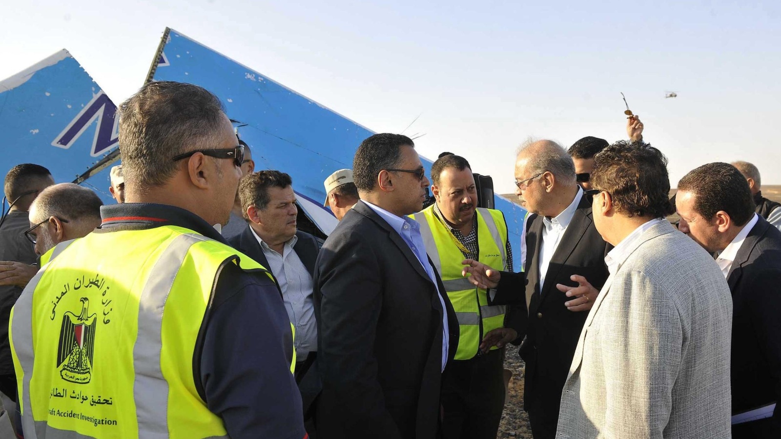 In this image released by the Prime Minister's office, Sherif Ismail, third right, along with military and government officials, visit the site where a passenger plane crashed in Hassana Egypt, Friday, Oct. 31, 2015. A Russian aircraft carrying 224 people, including 17 children, crashed Saturday in a remote mountainous region in the Sinai Peninsula about 20 minutes after taking off from a Red Sea resort popular with Russian tourists, the Egyptian government said. There were no survivors.(Suliman el-Oteify, Egypt Prime Minister's Office via AP)