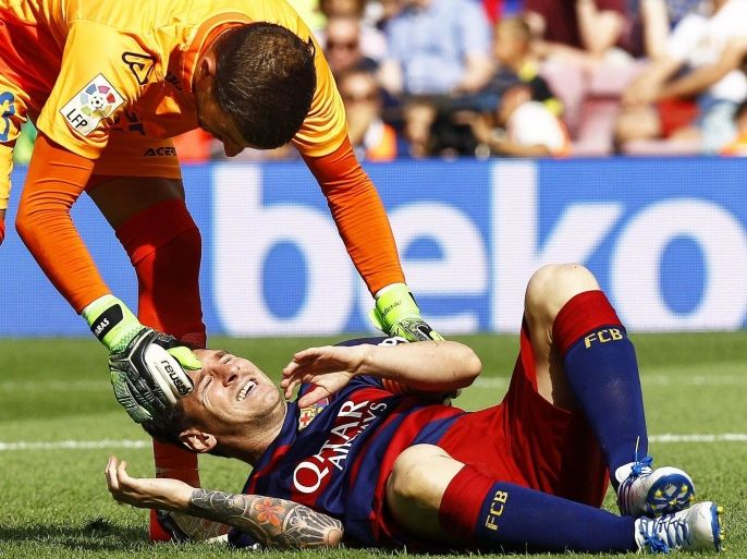 epaselect epa04950777 FC Barcelona's Argentinian striker Lionel Messi (R) lies on the pitch after being injured during the Spanish Primera Division soccer match between FC Barcelona and UD Las Palmas at Camp Nou in Barcelona, Spain, 26 September 2015. At left Las Palmas' goalkeeper Javi Varas.
