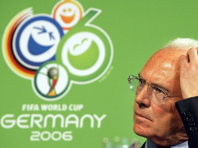 FILE - In this March 6, 2006 file photo German soccer legend Franz Beckenbauer gestures in front of the logo of the soccer world cup 2006 taking place in Germany during the FIFA team workshop in Duesseldorf, western Germany. German authorities are searching the premises of the country's soccer federation over payments made to FIFA in connection with the 2006 World Cup. (AP Photo/Frank Augstein, file)