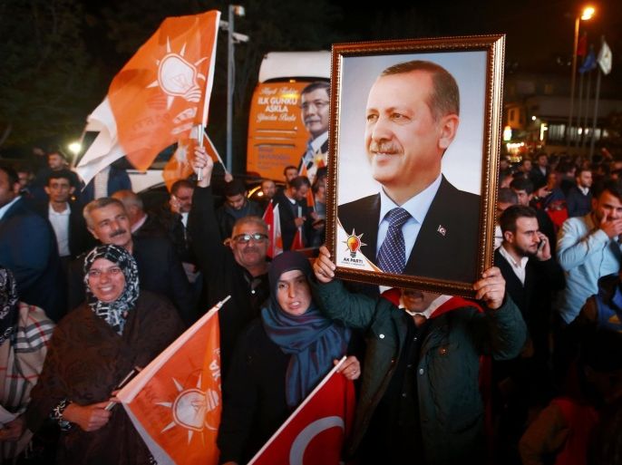 People wave flags and hold a portrait of Turkish President Tayyip Erdogan outside the AK Party headquarters in Istanbul, Turkey November 1, 2015. Turks went to the polls in a snap parliamentary election on Sunday under the shadow of mounting internal bloodshed and economic worries, a vote that could determine the trajectory of the polarised country and of President Tayyip Erdogan. The vote is the second in five months, after the AK Party founded by Erdogan lost in June the single-party governing majority it has enjoyed since first coming to power in 2002. REUTERS/Osman Orsal
