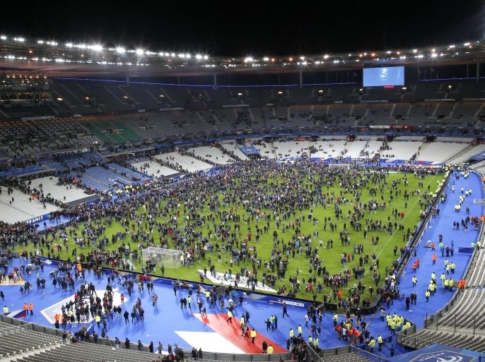Spectators invade the pitch of the Stade de France stadium after the international friendly soccer France against Germany, Friday, Nov. 13, 2015 in Saint Denis, outside Paris. At least 35 people were killed in shootings and explosions around Paris, many of them in a popular theater where patrons were taken hostage, police and medical officials said Friday. Two explosions were heard outside the Stade de France stadium. (AP Photo/Michel Euler)