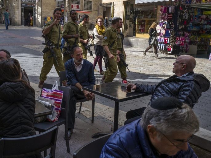 Israeli soldier armed with automatic assault rifles as they pass through central Jerusalem on a pedestrian walk street lined with shops and cafes, 18 November 2015. In the recent increase of stabbing attacks Israel has continued an increased security presence, and since the Paris attacks claimed by ISIS Prime Minister Benjamin Netanyahu has continuously stressed the importance of strongly attacking 'terror' groups wherever they exist.