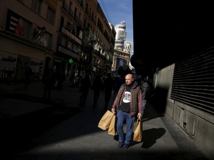 A man carries shopping bags in a shopping district in downtown Madrid, Spain, November 26, 2015. Spain's economy grew faster than most others in the euro zone from July to September, but falling wages, job insecurity and an unemployment rate of 21 percent are still weighing on many families. REUTERS/Susana Vera