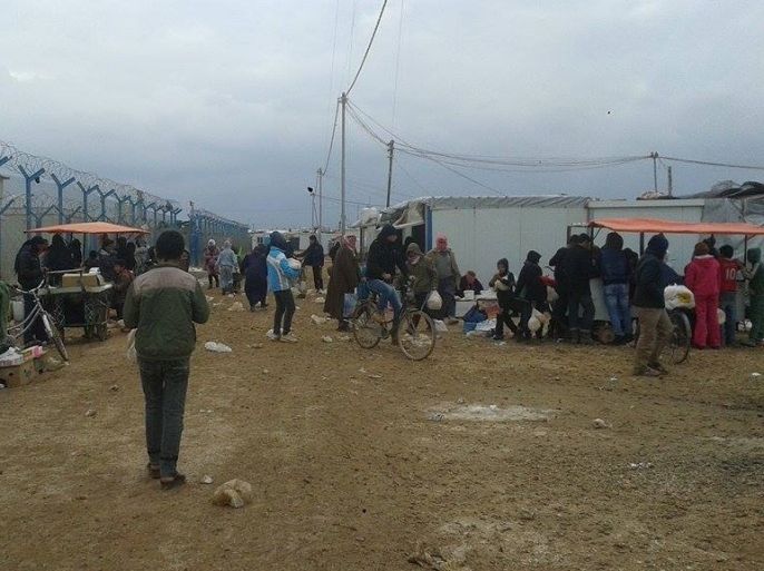 مخيم الزعتري للاجئين السوريين بالأردن- اللاجئون يتجمعون للحصول على الخبز في صباح بارد بالمخيم