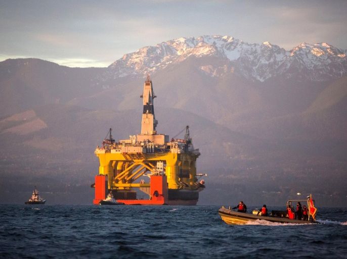 FILE - In this April 17, 2015 file photo, with the Olympic Mountains in the background, a small boat crosses in front of an oil drilling rig as it arrives in Port Angeles, Wash., aboard a transport ship after traveling across the Pacific. Royal Dutch Shell hopes to use the rig for exploratory drilling during the summer open-water season in the Chukchi Sea off Alaska's northwest coast, if it can get the permits. Ten environmental groups are calling on Interior Secretary Sally Jewell to halt plans by Royal Dutch Shell PLC for drilling in Arctic waters because one of the company’s icebreakers is scheduled for repair. (Daniella Beccaria/seattlepi.com via AP, File) MAGS OUT; NO SALES; SEATTLE TIMES OUT; TV OUT; MANDATORY CREDIT