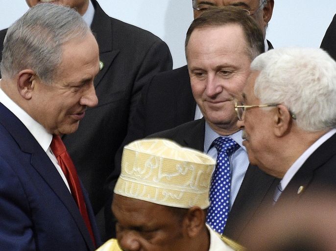 Israeli Prime Minister Benjamin Netanyahu, center left, talks with Palestinian President Mahmoud Abbas, center right, while New Zealand's Prime Minister John Key looks on as they wait to pose for a group photo as part of the COP21, the United Nations Climate Change Conference, in Le Bourget, outside Paris, Monday, Nov. 30, 2015. More than 150 world leaders are meeting under heightened security, for the 21st Session of the Conference of the Parties to the United Nations Framework Convention on Climate Change (COP21/CMP11), also known as "Paris 2015" from November 30 to December 11. (Martin Bureau/Pool Photo via AP)
