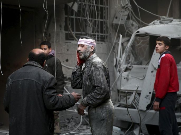 ATTENTION EDITORS - VISUAL COVERAGE OF SCENES OF DEATH AND INJURYAn injured man stands in a site hit by what activists said were airstrikes carried out by the Russian air force in the town of Douma, eastern Ghouta in Damascus, Syria January 10, 2016. REUTERS/Bassam Khabieh