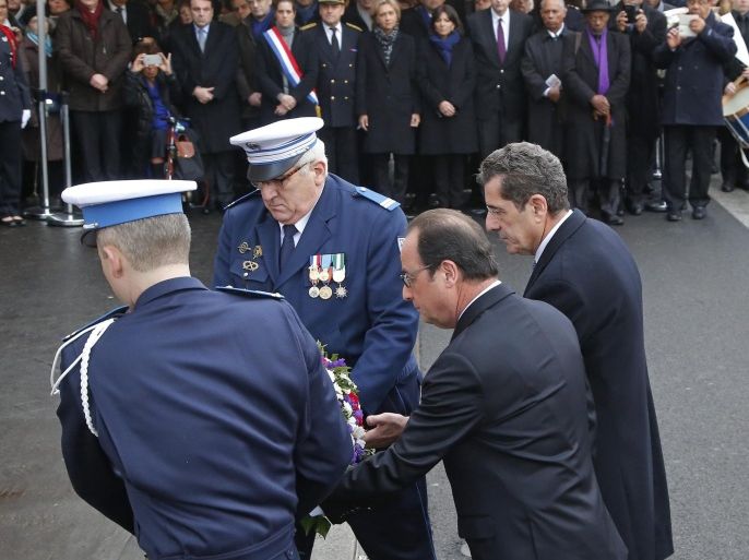 French President Francois Hollande (C) and the mayor of Montrouge, Jean-Loup Metton (R), lay a wreath of flowers honoring late policewoman Clarissa Jean-Philippe, in Montrouge, south of Paris, France, 09 January 2016. Hollande is honoring 17 victims killed in Islamic extremist attacks on satirical newspaper Charlie Hebdo, a kosher market and police a year ago this week, unveiling plaques around Paris marking violence that ushered in a tumultuous year. EPA/MICHEL EULER / POOL MAXPPP OUT