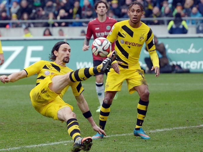 Dortmund's Neven Subotic from Serbia tries a bicycle kick , while teammate Pierre-Emerick Aubameyang from Gabon looks on during the German first division Bundesliga soccer match between Hannover 96 and Borussia Dortmund in Hannover, Germany Saturday March 21, 2015. (AP Photo/dpa, Peter Steffen)