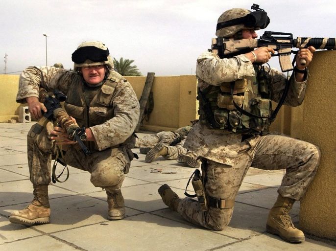 FILE - In this Sunday, Oct. 31, 2004 file photo, U.S. Marine snipers from the 2nd Battalion, 5th Marine Regiment, take cover during a gun battle with insurgents in Ramadi in Anbar province, Iraq. U.S. President Barack Obama said Friday, Nov. 7, 2014, that he authorized the deployment of up to 1,500 more American troops to bolster Iraqi forces. For the first time since the U.S. withdrawal in December 2011, American military personnel will be on the ground in Iraq’s historically dangerous Anbar province, helping train the Iraqi military for its fight against the Islamic State group. Anbar resonates with many Americans because they recall how costly the fighting was there for U.S. troops. More than 3,500 U.S. soldiers died in combat in Iraq between 2003 and 2011 - and there are concerns that sending Americans back to Anbar in any capacity will inevitably make them a target. (AP Photo/Jim MacMillan, File)