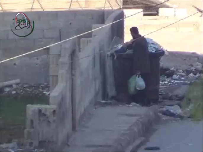 ‪الأهالي يبحثون في القمامة عما يُسكتون به جوعهم في معضمية الشام‬ (ناشطون)