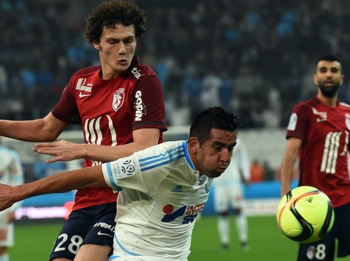 2265 - Marseille, Bouches-du-Rhône, FRANCE : Lille's defender Benjamin Pavard (L) vies with Marseille's Chilian midfielder Mauricio Anibal Isla during the French L1 football match between Marseille and Lille at Velodrome Stadium in Marseille on January 29, 2016. AFP PHOTO / ANNE-CHRISTINE POUJOULAT