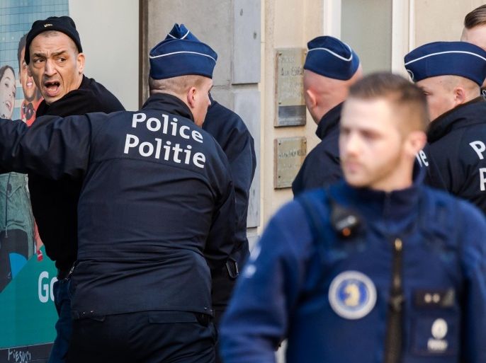 Police officers detain a man in the historic center in Brussels on Thursday, Dec. 31, 2015. The New Year's Eve fireworks display and all official events are being canceled in Belgium's capital due to threats of an extremist attack. It was not known why the man was detained. (AP Photo/Geert Vanden Wijngaert)