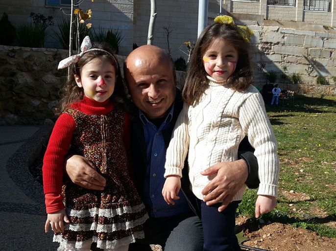 رائد زعبي أحد مسؤولي مؤسسة الإغاثة الإنسانية للعون داخل أراضي 48 مع طفلتين يتيمتين من منطقة الخليل في الضفة الغربية.