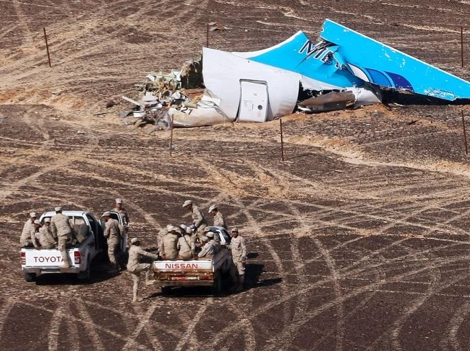 FILE - In this Sunday, Nov. 1, 2015 file photo provided by Russian Emergency Situations Ministry, Egyptian Military on cars approach a plane's tail at the wreckage of a passenger jet bound for St. Petersburg in Russia that crashed in Hassana, Egypt. The Russian passenger plane that crashed in Egypt was brought down by a homemade bomb placed on board in a "terrorist" act, the head of Russia's FSB security service told President Vladimir Putin on Tuesday, Nov. 17, 2015. (Maxim Grigoriev/Russian Ministry for Emergency Situations via AP, File)
