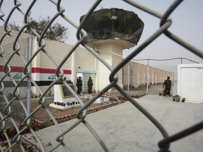 FILE - In this Feb. 21, 2009 file photo, guards stand at the entrance of a renovated Abu Ghraib prison, now renamed Baghdad Central Prison and run by Iraqis, in Baghdad, Iraq. A military-style assault by al-Qaida leader Abu Bakr al-Baghdadi’s fighters on two Baghdad-area prisons in July, 2013 freed more than 500 inmates.(AP Photo / Karim Kadim, File)