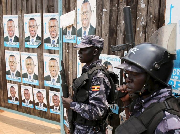 Policemen stand in front of the gate of opposition leader Kizza Besigye's office in Kampala, Uganda February 19, 2016. Ugandan police shot in the air and fired tear gas at opposition protesters in several parts of southern Kampala on Friday, a Reuters witness said, after the presidential election a day earlier. REUTERS/Goran Tomasevic