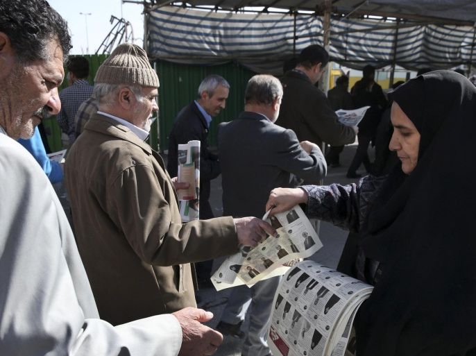 An Iranian woman distributes electoral leaflets of a group of conservative candidates of the upcoming parliamentary elections after the Friday prayers ceremony at the Imam Khomeini grand mosque in Tehran, Iran, Friday, Feb. 19, 2016. Iran will hold elections for 290-seat parliament and 88-member Assembly of Experts clerical body on Feb. 26. (AP Photo/Vahid Salemi)
