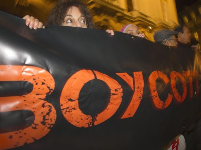 FILE - In this Wednesday, Oct. 31, 2012 file photo, French demonstrators and supporters of Palestinians hold a placard with the word "Boycott" during a demonstration in Paris, France. A campaign called BDS, which was started by Palestinian activists 10 years ago to boycott Israel, has grown into a worldwide network of thousands of volunteers lobbying corporations, artists and academic institutions to sever ties with Israel. (AP Photo/Jacques Brinon, File)
