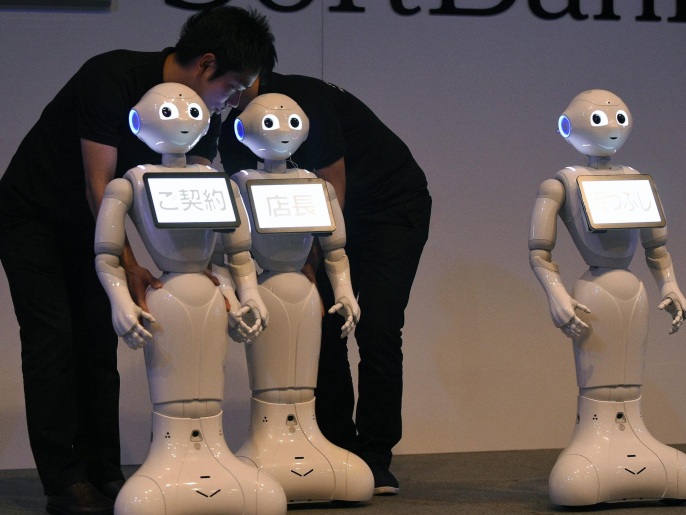 Staff members display humanoid robots Pepper on stage during the press conference of the 'Pepper World 2016' in Tokyo, Japan, 27 January 2016. Organized by telecommunications and mobile phone carrier SoftBank Corp., the event displays the robot Pepper in different business applications such as retailing, health care and education.