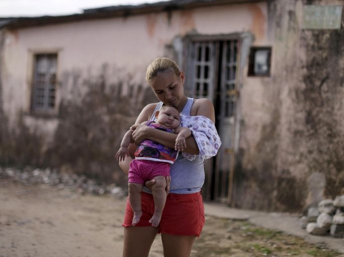 Gleyse Kelly da Silva holds her daughter Maria Giovanna, who has microcephaly, in front their house in Recife, Brazil, January 30, 2016. Picture taken on January 30, 2016. To match story HEALTH-ZIKA/INEQUALITY REUTERS/Ueslei Marcelino