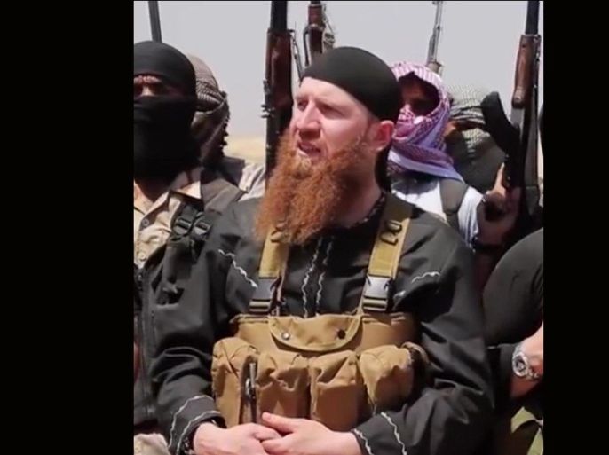 This image made from undated video posted during the weekend of June 28, 2014 on a social media account frequently used for communications by the Islamic State of Iraq and the Levant (ISIL), which has been verified and is consistent with other AP reporting, shows Omar al-Shishani standing next to the group's spokesman among a group of fighters as they declare the elimination of the border between Iraq and Syria. Al-Shishani, one of hundreds of Chechens who have been among the toughest jihadi fighters in Syria, has emerged as the face of the Islamic State of Iraq and the Levant, appearing frequently in its online videos — in contrast to the group's Iraqi leader, Abu Bakr al-Baghdadi, who remains deep in hiding and has hardly ever been photographed. (AP Photo/militant social media account via AP video)