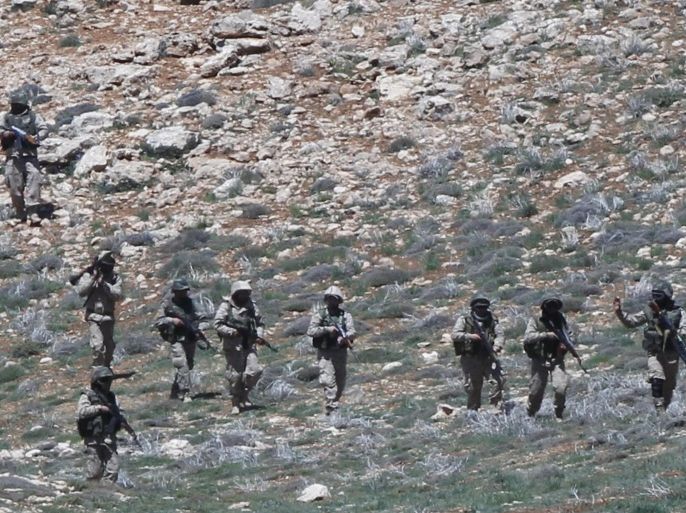Lebanon's Hezbollah fighters carry their weapons as they walk in Khashaat, in the Qalamoun region after they advanced in the area May 15, 2015. When Lebanon's Hezbollah first joined Syria's war on the side of President Bashar al-Assad, its role was a closely guarded secret. Today, as Hezbollah plants its flag in land won from rebels north of Damascus, its role could hardly be more public. Picture taken May 15, 2015. To match Insight MIDEAST-CRISIS/SYRIA REUTERS/Mohamed Azakir