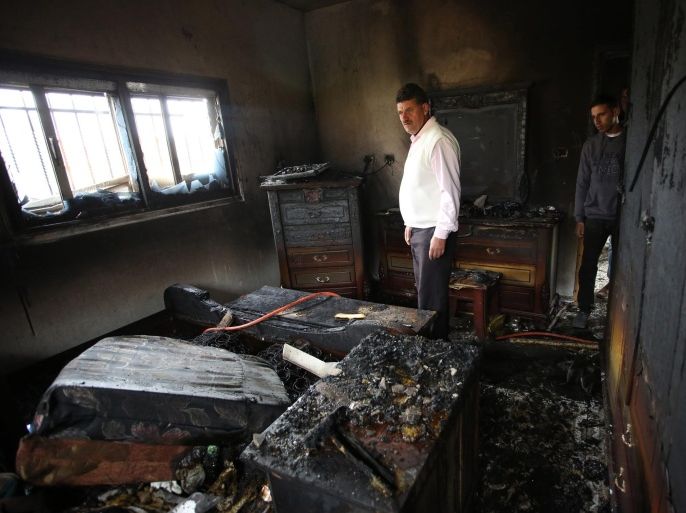 Palestinian men inspect the damage at the burned house of Ibrahim Dawabsha, from the West Bank village of Duma, 20 March 2016. Ibrahim Dawabsha is a key witness in the firebombing attack carried out by Jewish extremists on July 2015 against Dawabsha family that killed an 18-month-old boy with his two parents. Palestinian media report that according to Duma residents; the window of the family bedroom was broken and a Molotov cocktails were thrown inside, raising suspicions of a second arson attack in the village. Ibrahim Dawabsha was not hurt in the fire incident.
