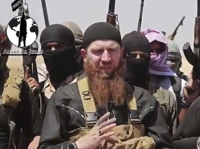 This image made from undated video posted during the weekend of June 28, 2014 on a social media account frequently used for communications by the Islamic State of Iraq and the Levant (ISIL), which has been verified and is consistent with other AP reporting, shows Omar al-Shishani standing next to the group's spokesman among a group of fighters as they declare the elimination of the border between Iraq and Syria. Al-Shishani, one of hundreds of Chechens who have been among the toughest jihadi fighters in Syria, has emerged as the face of the Islamic State of Iraq and the Levant, appearing frequently in its online videos — in contrast to the group's Iraqi leader, Abu Bakr al-Baghdadi, who remains deep in hiding and has hardly ever been photographed. (AP Photo/militant social media account via AP video)