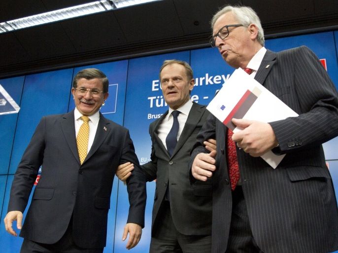 Turkish Prime Minister Ahmet Davutoglu, left, stands with European Council President Donald Tusk, center, and European Commission President Jean-Claude Juncker at the end of an EU summit in Brussels on Friday, March 18, 2016. The European Union and Turkey have reached a landmark deal to ease the migrant crisis and give Ankara concessions on better EU relations, The Czech prime minister announced Friday. (AP Photo/Virginia Mayo)