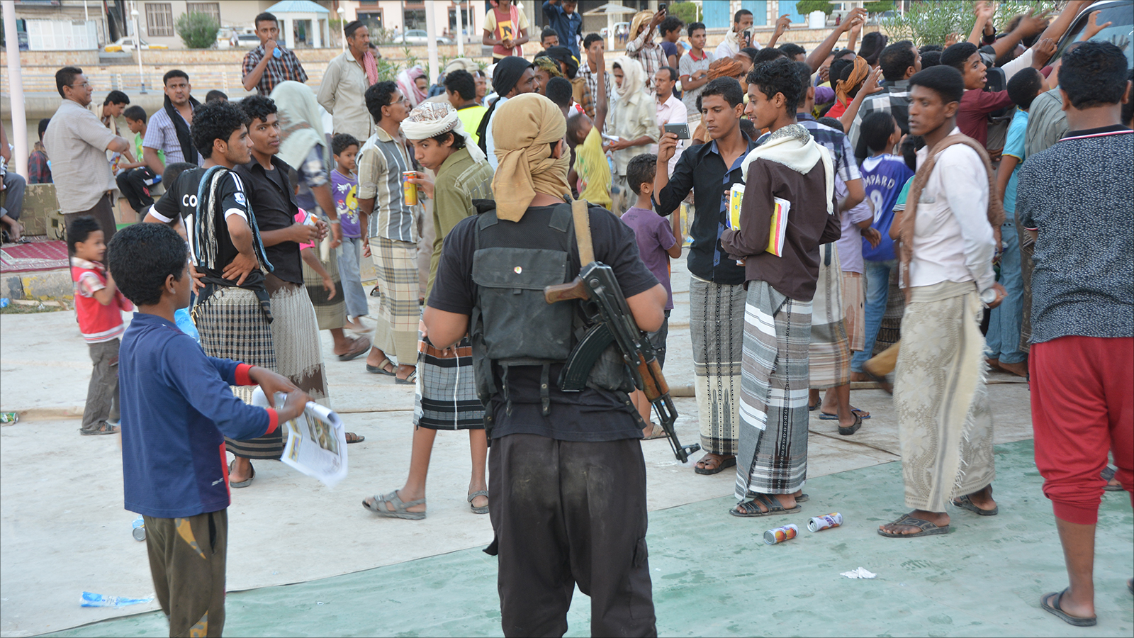 ‪مسلح من القاعدة يقف أمام مواطنين بالمكلا‬ (الجزيرة)